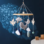 Wooden crochet stars baby crib mobile with bell rattle toy by Nova Mart hanging from a crib.