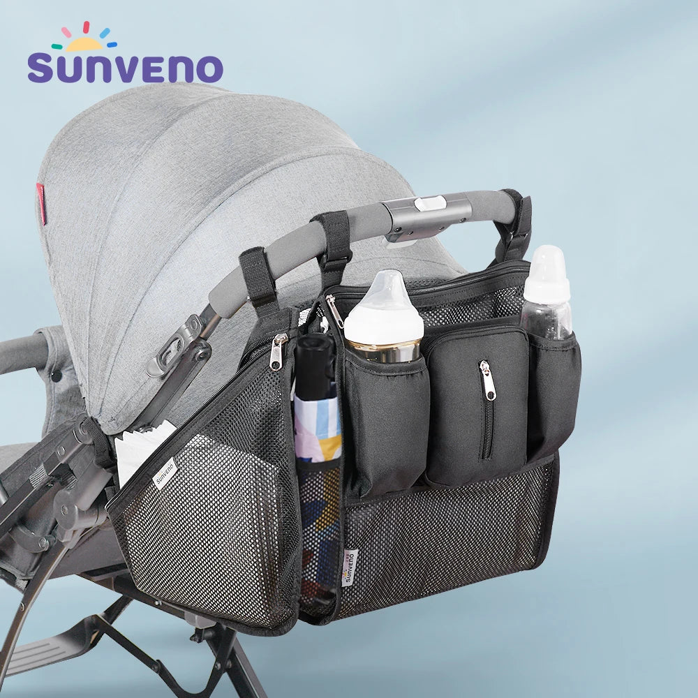 Sunveno baby stroller organizer bag by Nova Mart with multiple storage compartments and adjustable straps, attached to a stroller.