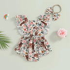 Baby girl in cow print romper with matching headband, Nova Mart western cowgirl outfit for infants.