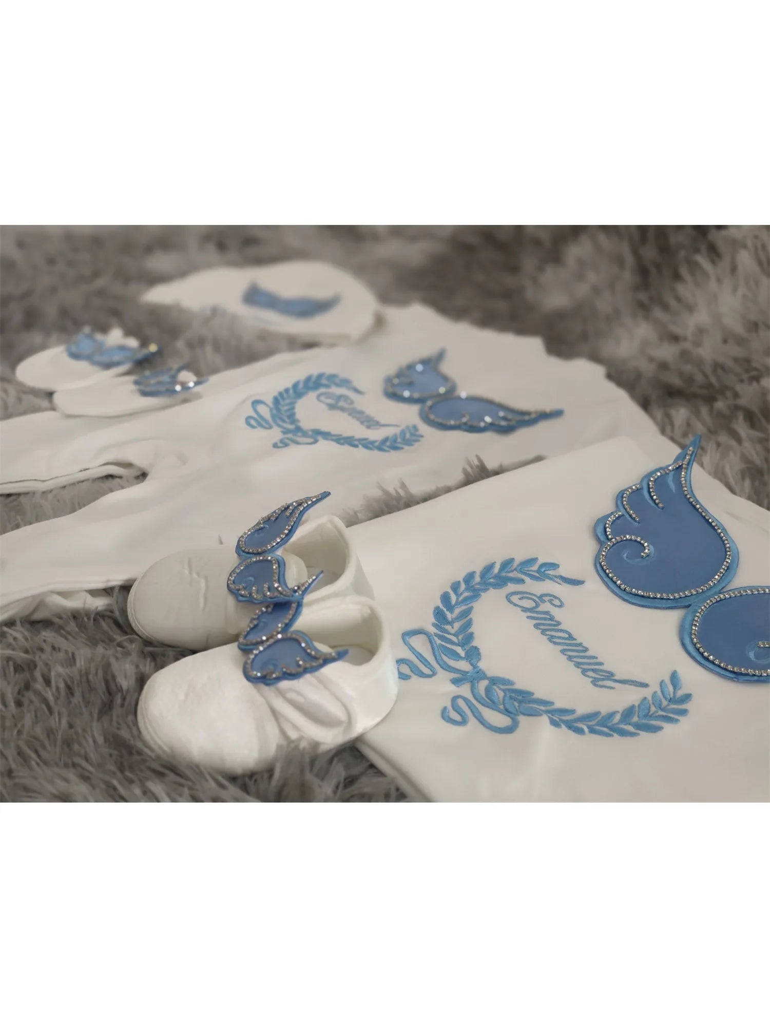 White and blue embroidered newborn angel wings outfit set for babies, made by Nova Mart, featuring soft baby clothing with angel wing details.