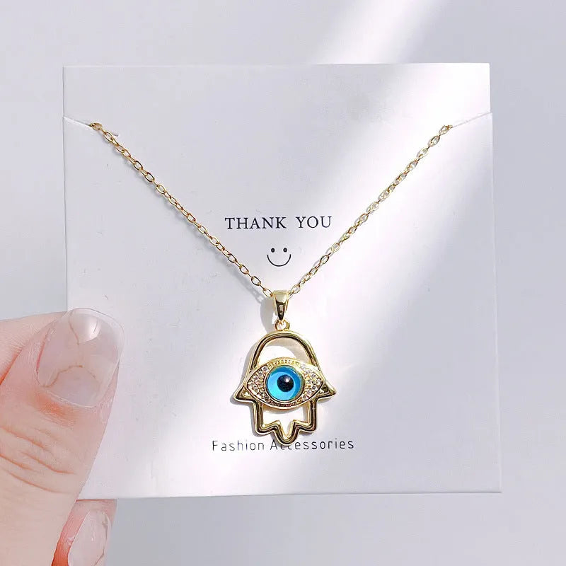 Silver Evil Eye Hamsa Hand necklace for women, featuring protective evil eye charm and intricate jewelry design.