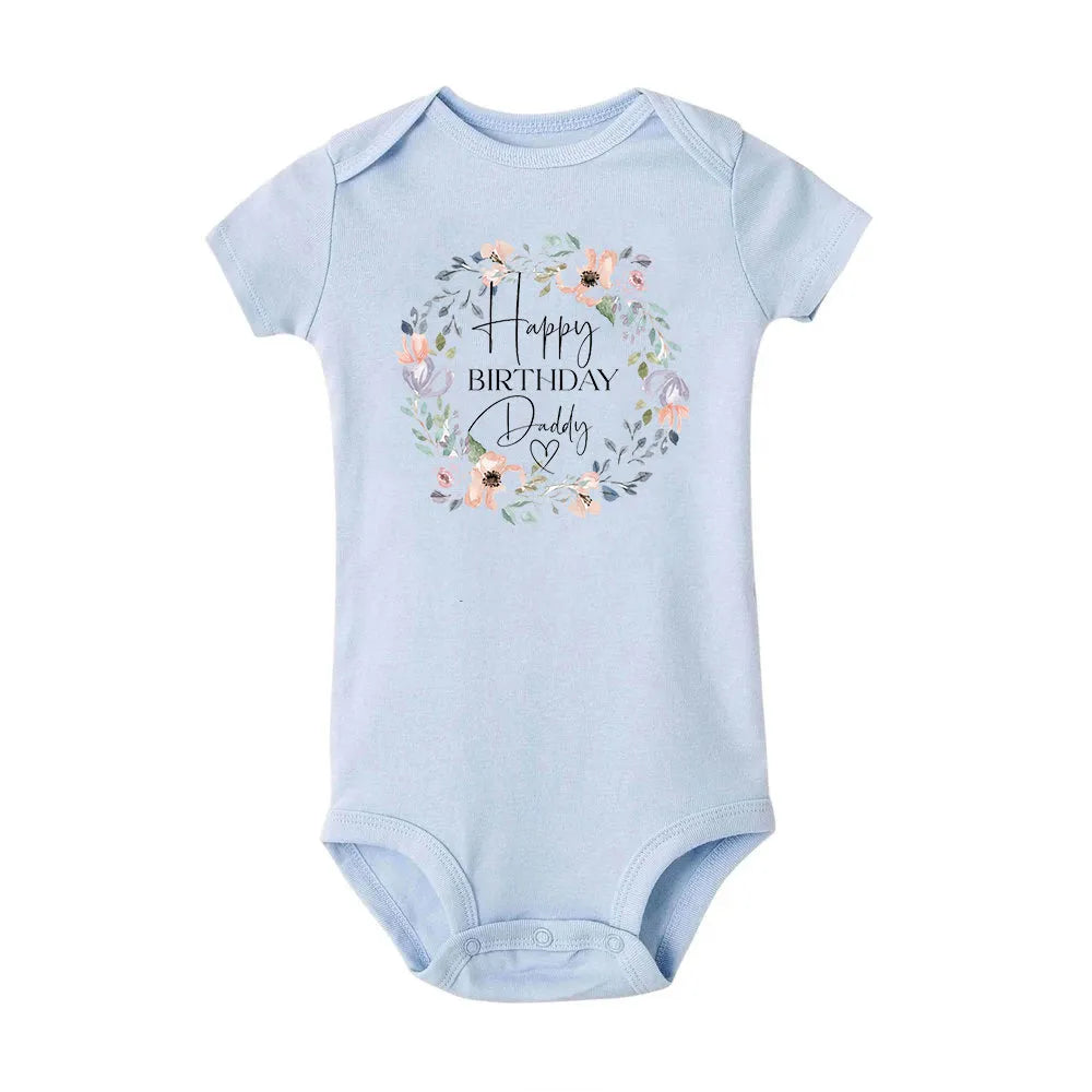 Baby boy in a navy short-sleeve Happy Birthday Daddy bodysuit by Nova Mart, summer romper with festive birthday print.
