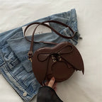 Nova Mart heart-shaped bag with bat wing design, one-shoulder crossbody style featuring a unique strap and bold gothic details.