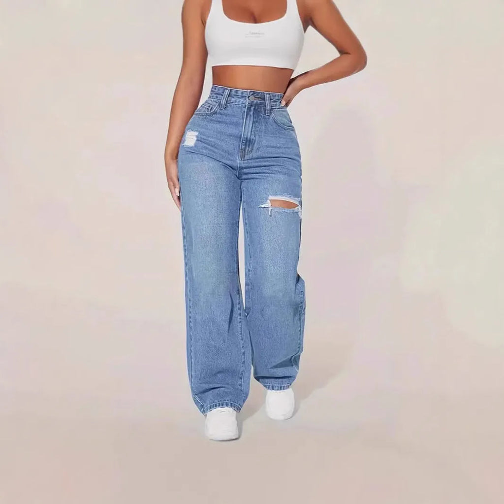 Women's washed ripped denim jeans by Nova Mart featuring distressed details and classic fit, displayed on a model.