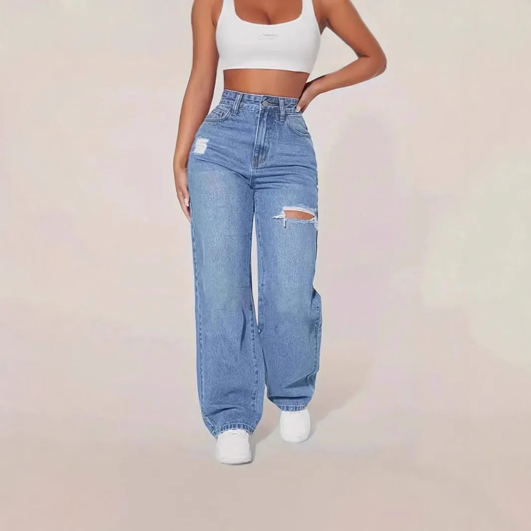 Women's washed ripped denim jeans by Nova Mart featuring distressed details and classic fit, displayed on a model.