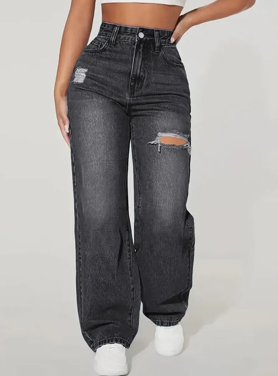 Women's washed ripped denim jeans by Nova Mart with distressed details and a relaxed fit, shown on a model.